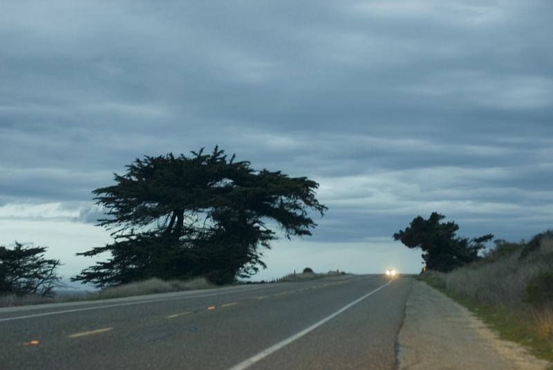 Low angle view with an approaching car with headlights illuminated on Highway 1 on the Big Sur Coast, California