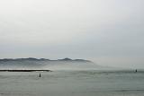 Morro Bay coastline in California with a calm flat ocean and light sea mist