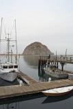 Small Boats at the Dock of Beautiful Morro Bay, Captured with Famous Big Rock. Isolated on Light Gray Sky Background.