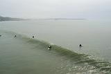 Professional Surfers at Beautiful California Beach in Aerial Extensive View. Isolated on Foggy Sky Background.