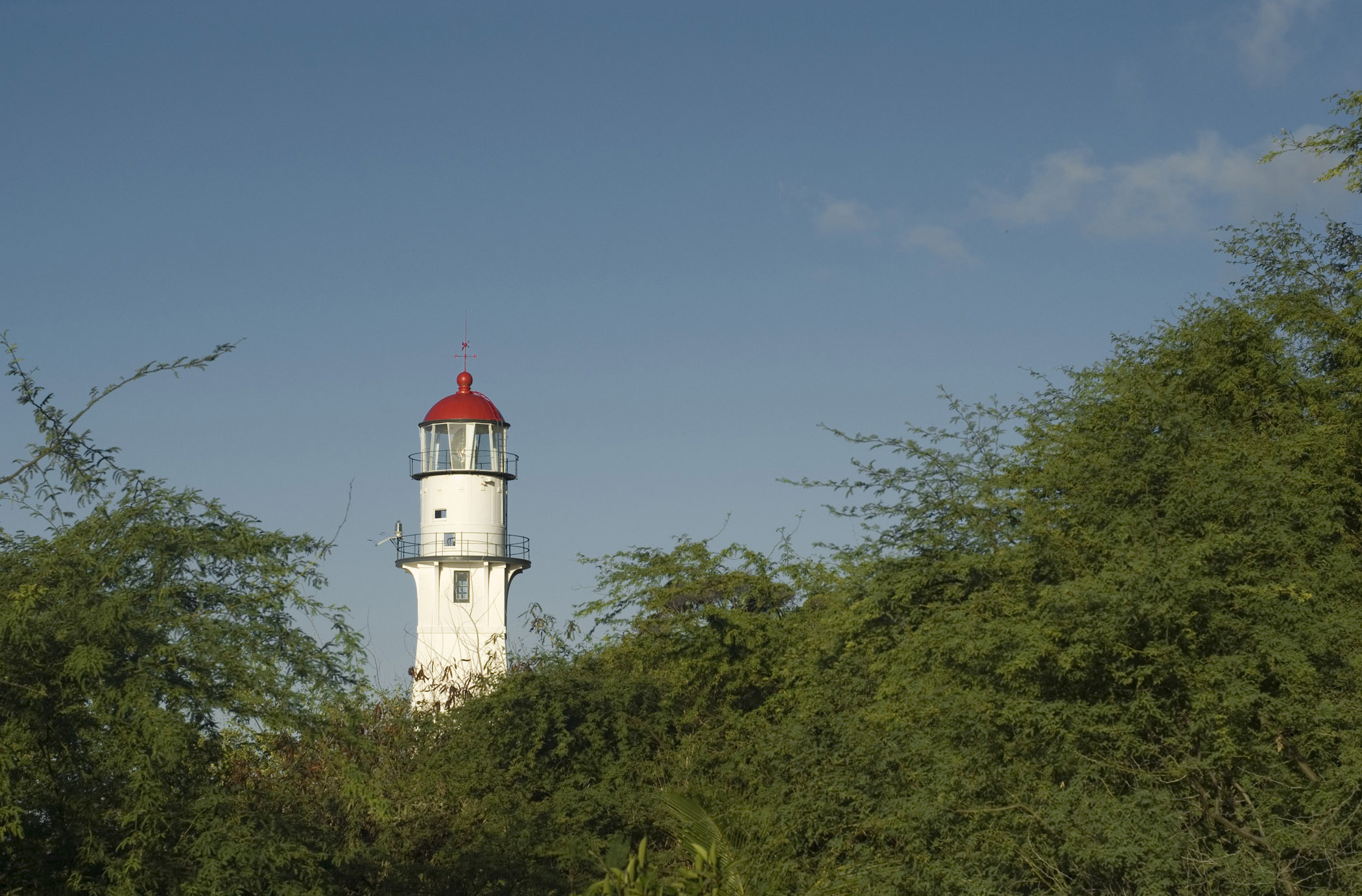 an image of View across green vegetation of the lamp and tower of the Diamond Head Lighthouse, Honolulu, Hawaii