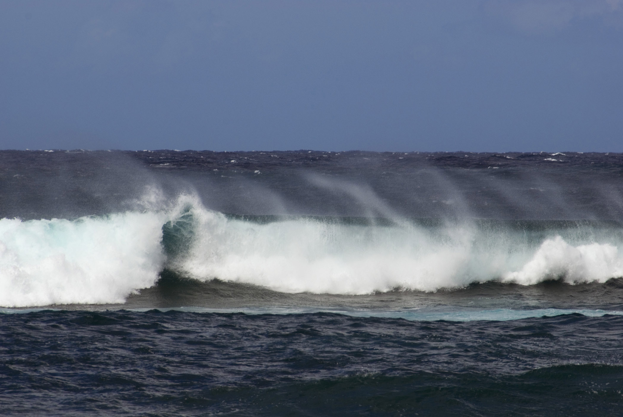 an image of Big waves off the North Shore, Hawaii with spray whipped up by the wind, a popular area for surfers