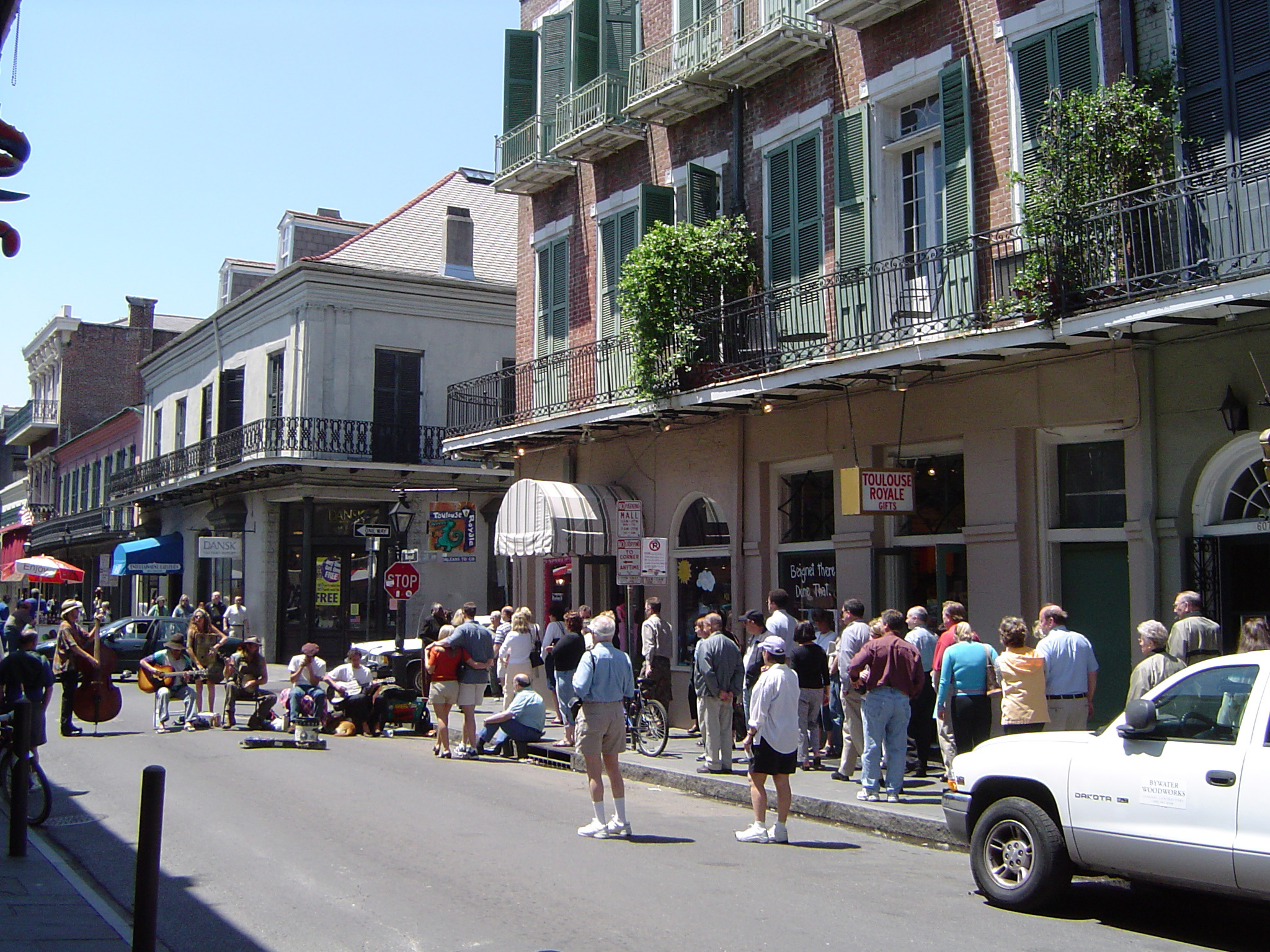 an image of Random Busy People at City Street of New Orleans. Captured Concrete Buildings Portrait.