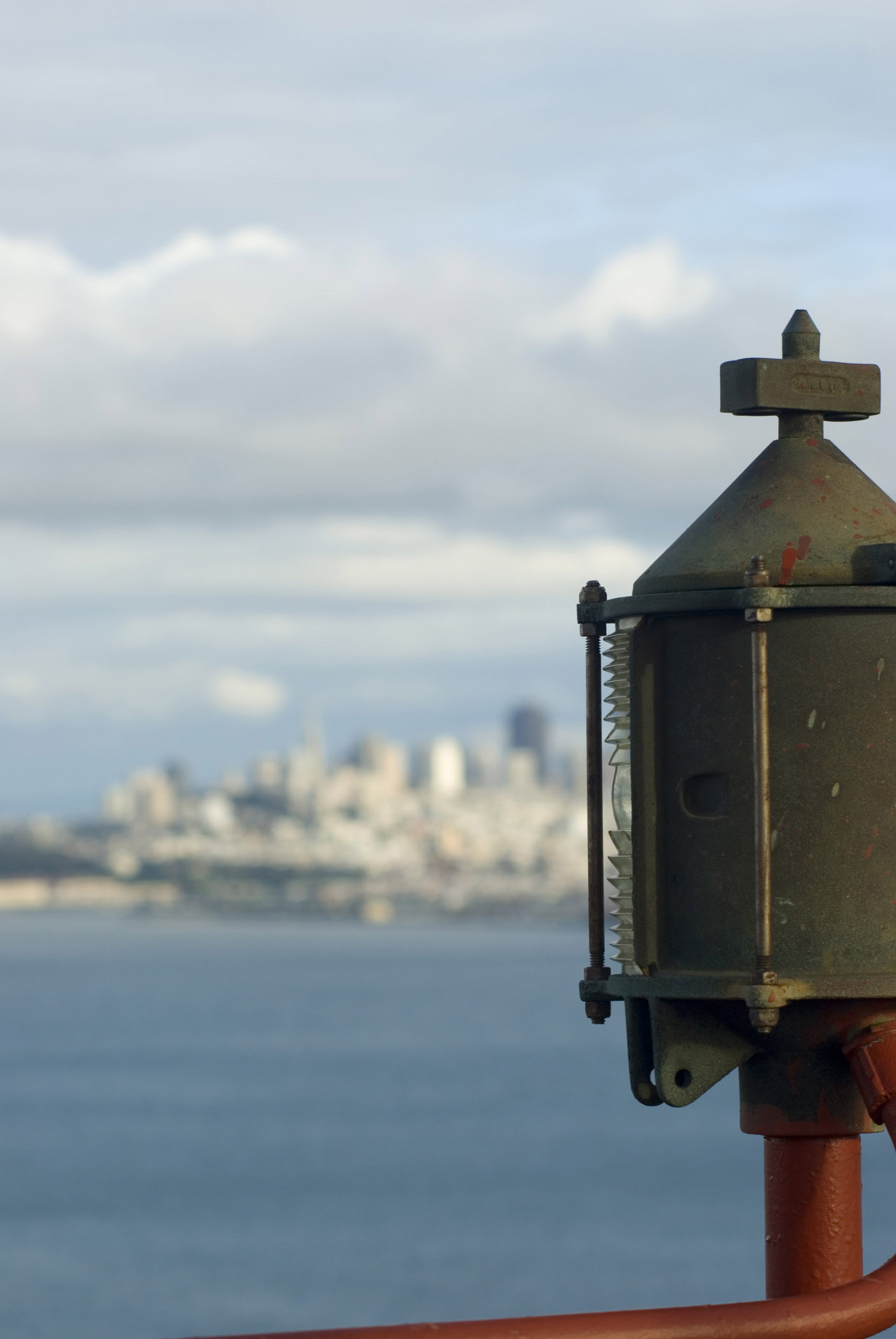 an image of Macro Vintage Metallic Object From Golden Gate Bridge. Isolated on Blue Water Bay and Lighter Blue Sky Background.
