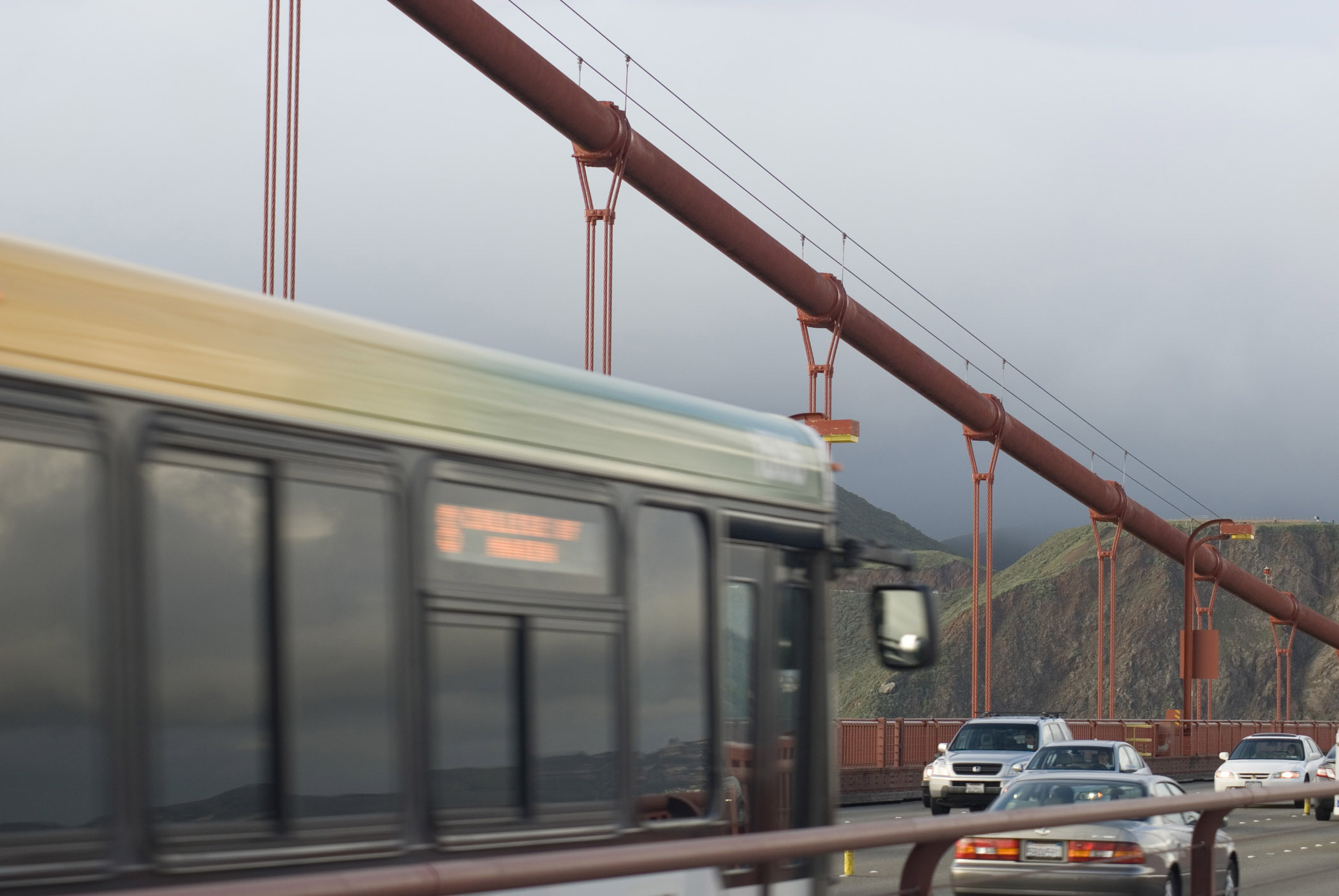 an image of Traffic on the Golden Gate bridge, California driving with headlights on a misty overcast day
