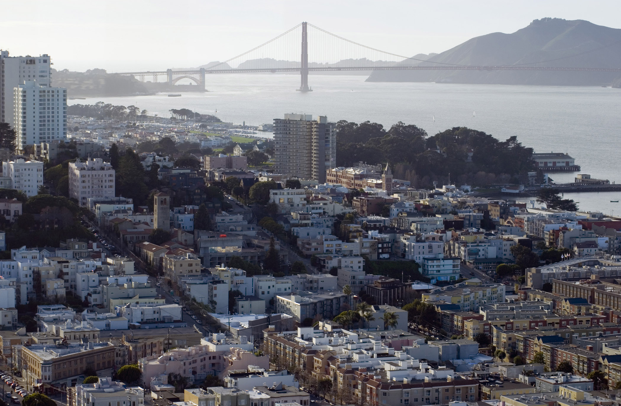 an image of Plenty City Building Infrastructures and Famous Golden Gate Bridge at Far Distant. Captured on a misty morning.