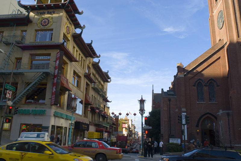 View of a busy street in China Town, San Francisco with traffic, pedestrians, stores and Asian style architecture