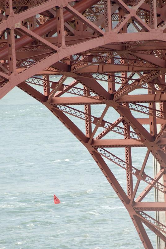 Golden Gate Bridge, San Francisco, detail under the arch showing the red metal lattice framework with the sea beyond