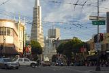Street level scene of a busy intersection with traffic and pedestrians on Columbus Avenue San Francisco with the Transamerica Pyramid behind