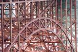 Detail of an arch on the Golden Gate Bridge showing the metal lattice framework and red paintwork