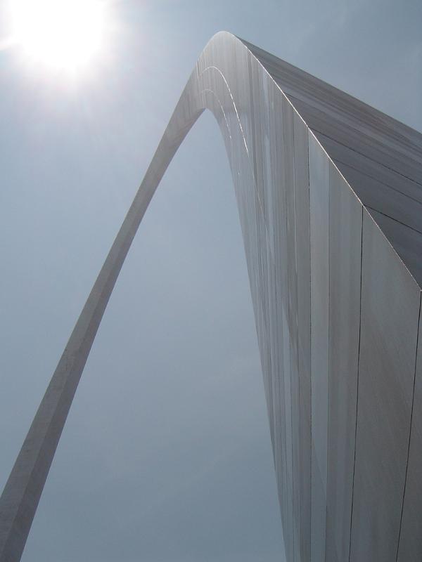 View looking up the curve of the Gateway Arch, St Louis, USA against a blue sky with sunburst