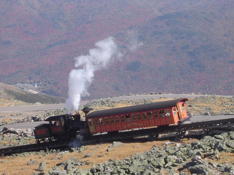 Steam Locomotive Passing Cog Railway Vintage Steam Locomotive Passing Cog Railway on Rocky Landscape. Captured with Mountains Background.