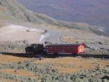 Mount Washington Cog Railway steam train negotiating a steep incline above a parking lot, USA