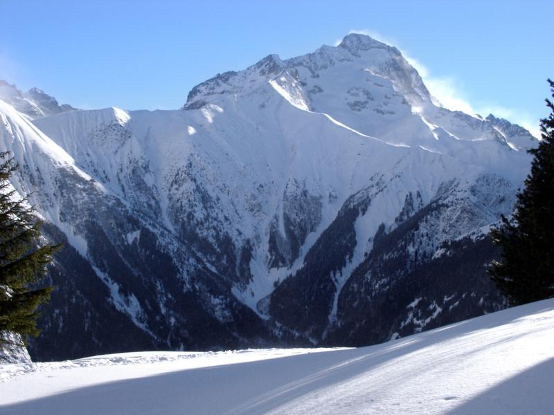 French Mountains Covered with Ice Snow During Winter Season on Light Blue Sky Background.