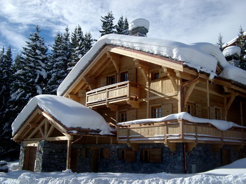 Traditional snow covered alpine lodge Scenic view of a traditional wooden snow covered alpine lodge set amongst evergreen fir trees in a steep mountain valley
