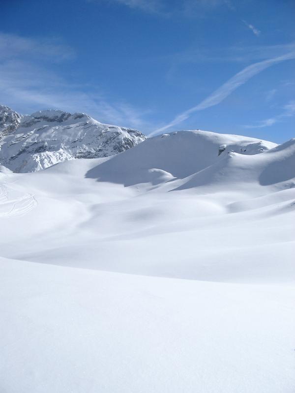 Scenic mountain view in winter with snow Scenic mountain view in winter with snow covered peaks and pristine white fresh snow on the ground under a clear sunny blue winter sky