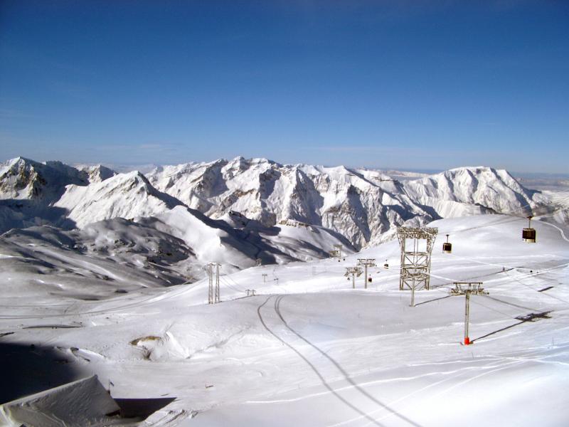 Winter landscape with a piste Scenic winter landscape with snow covered mountains and a piste with chair lifts for skiers