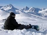 Snowboarder in Black Jacket Relaxing During Winter Holiday Season.