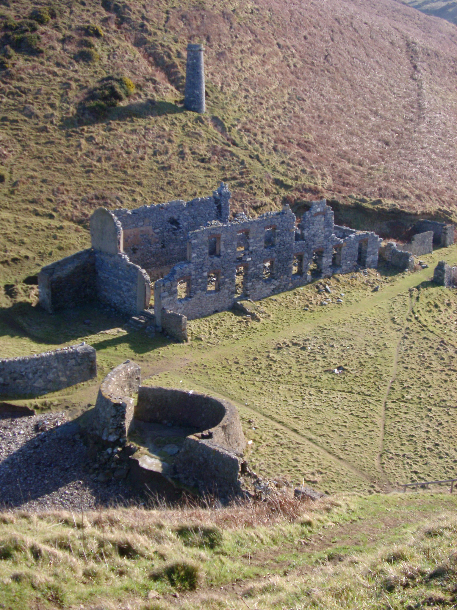 an image of Ruins of an old factory with stone walls and an old iron smelter viewed high angle in a valley