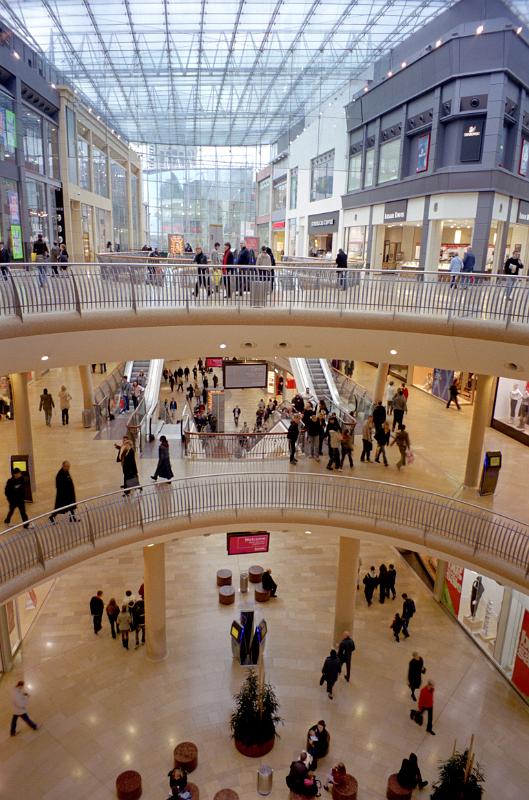 Inside the new Bullring shopping centre in Birmingham showing various walkways with groups of shoppers and a variety of stores