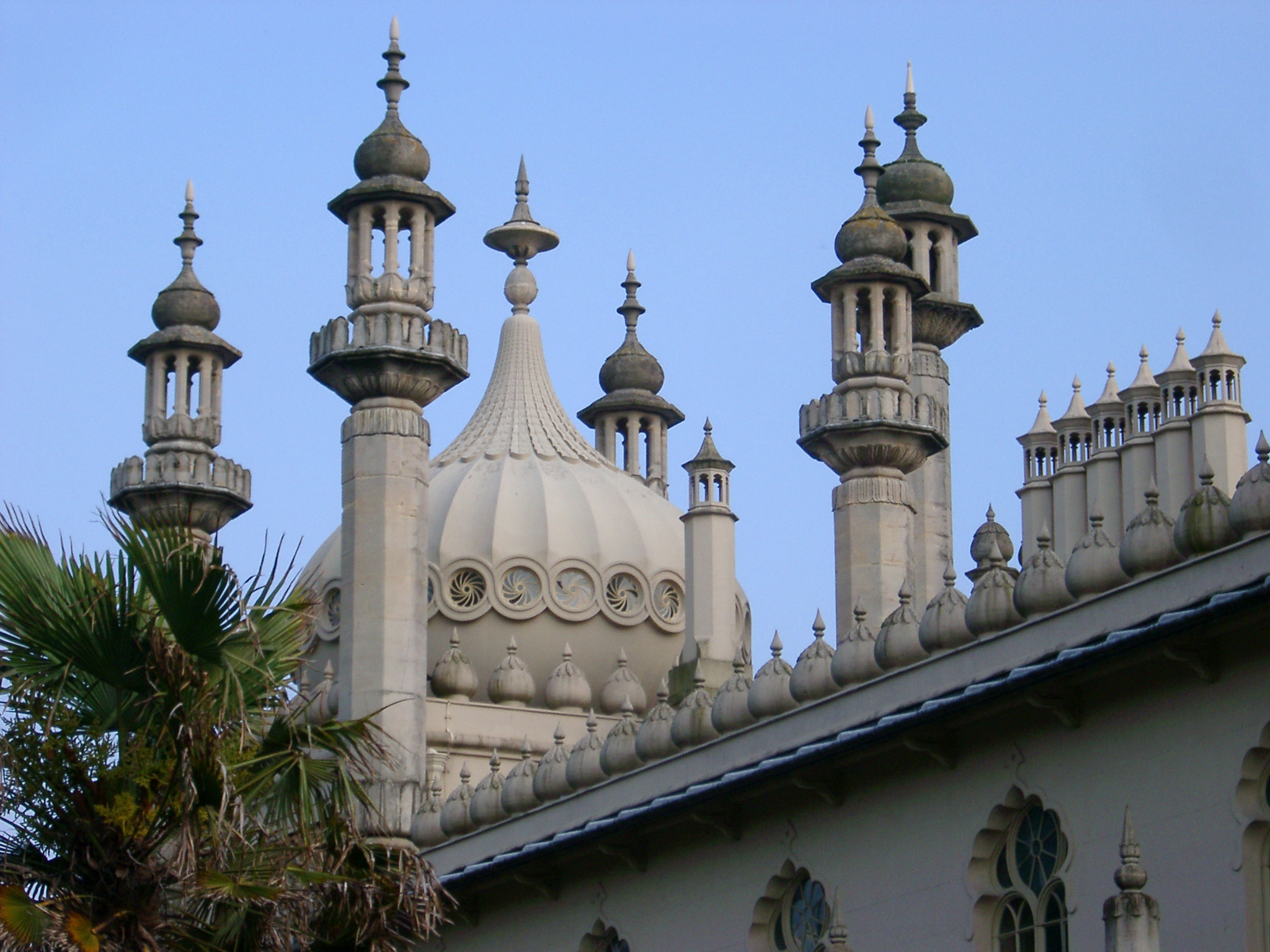 an image of Famous Architectural Exterior Design, Emphasizing Dome, of Royal Pavilion Building in Brighton, England, United Kingdom. Captured on the Afternoon with Light Blue Sky Background.