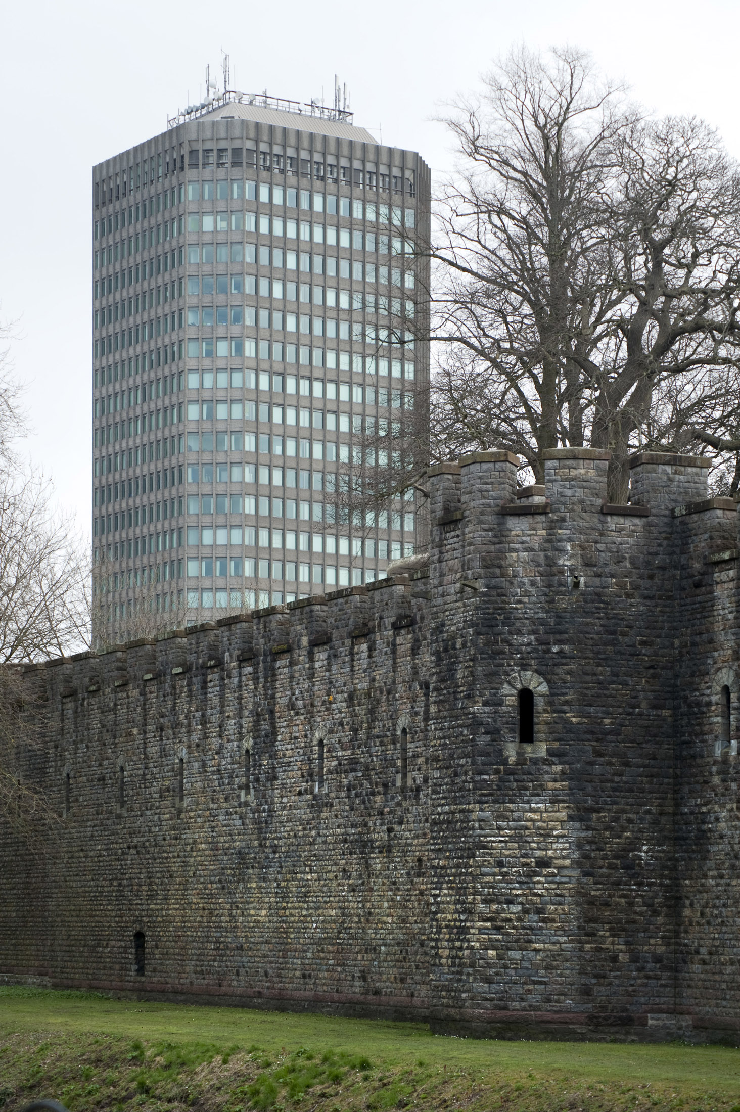 an image of old and modern cardiff, the castle walls and an office block