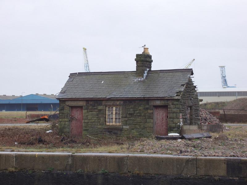 Derelict docklands with ramshackle old buildings and wasteland in Cardiff Bay, Wales
