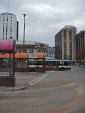 Depressing view of the Central Bus Station in Cardiff with rows of shelters and a departing bus on a dismal grey cloudy day