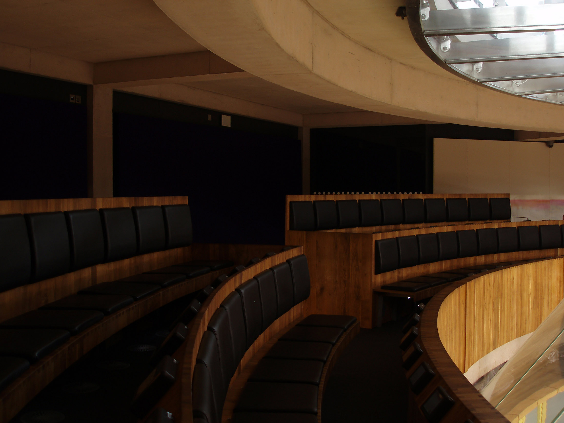 an image of Empty Chairs with Small TV monitors in Front at Siambr Public Gallery in The Senedd. Located in Cardiff, Wales.