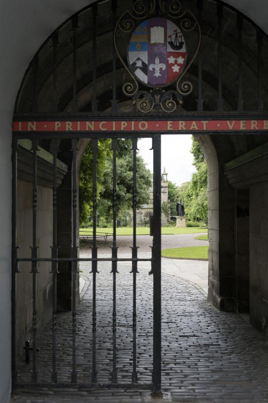 View of the grounds through a wrought iron entrance gate to St Andrews University, Scotland