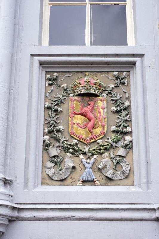 St Andrews University crest in relief on a wall below a window on the external facade of one of the historic buildings at the prestigious Scottish university