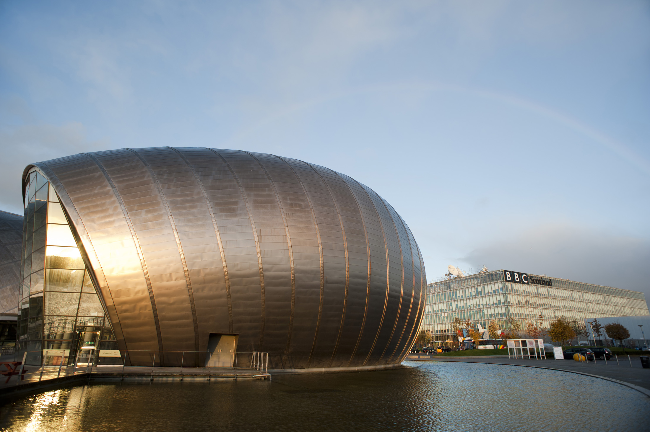 an image of Glasgow Princes Dock Development with the curved metal clad facade of the Glasgow Science Centre on the River Clyde