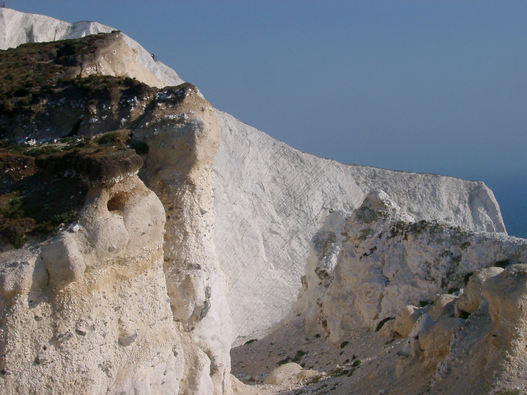 an image of Close up Famous Textured Chalk Cliffs at Whitecliff Bay on the Isle of Wight. Captured with Blue Gray Sky Background.