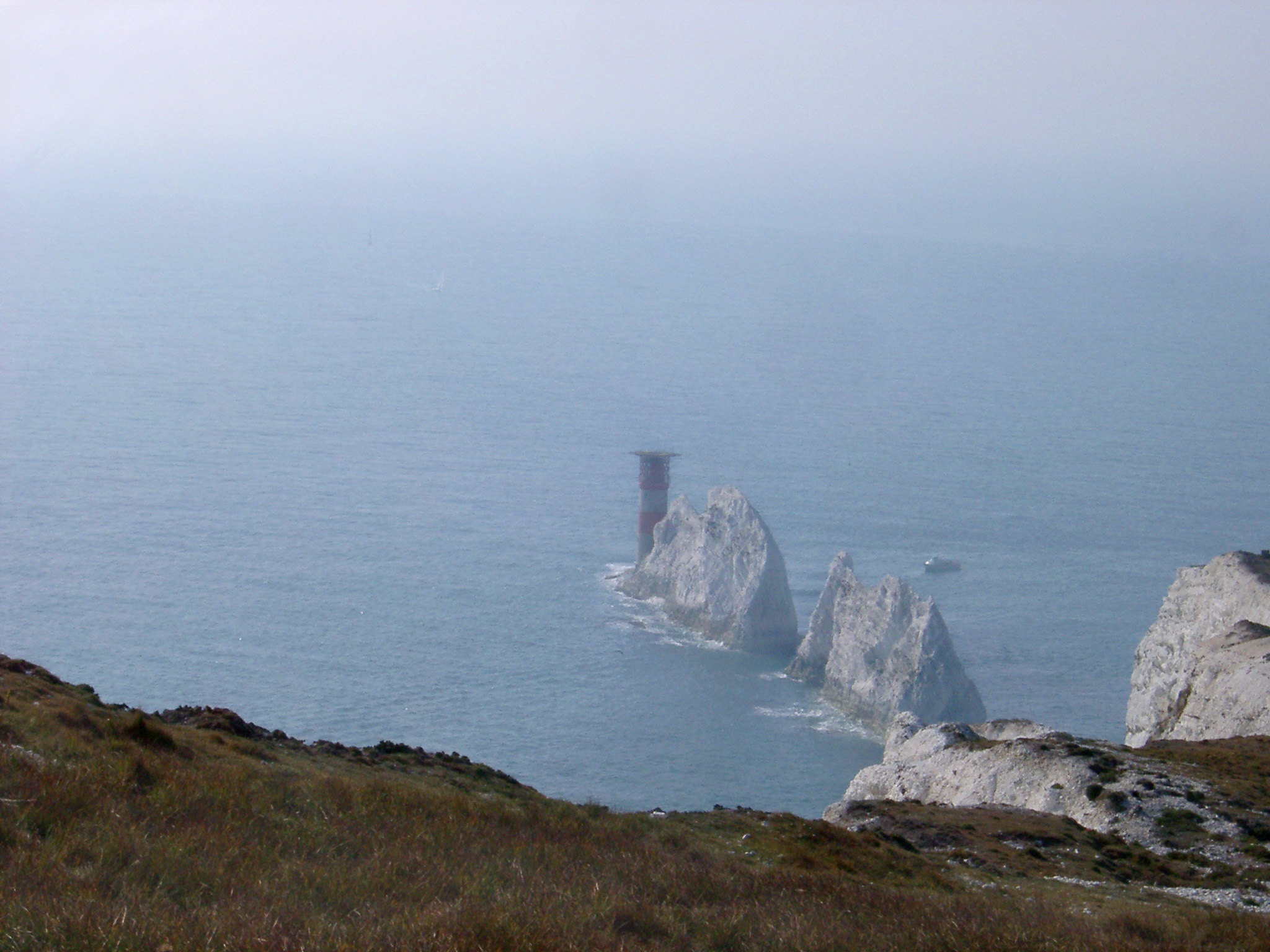 an image of View from the headland looking down on the The Needles, a row of chalk stacks rising directly from the ocean on the Isle of Wight