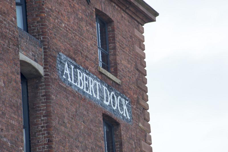Detail on Albert Dock painted brick sign in between windows in Liverpool with over cast sky