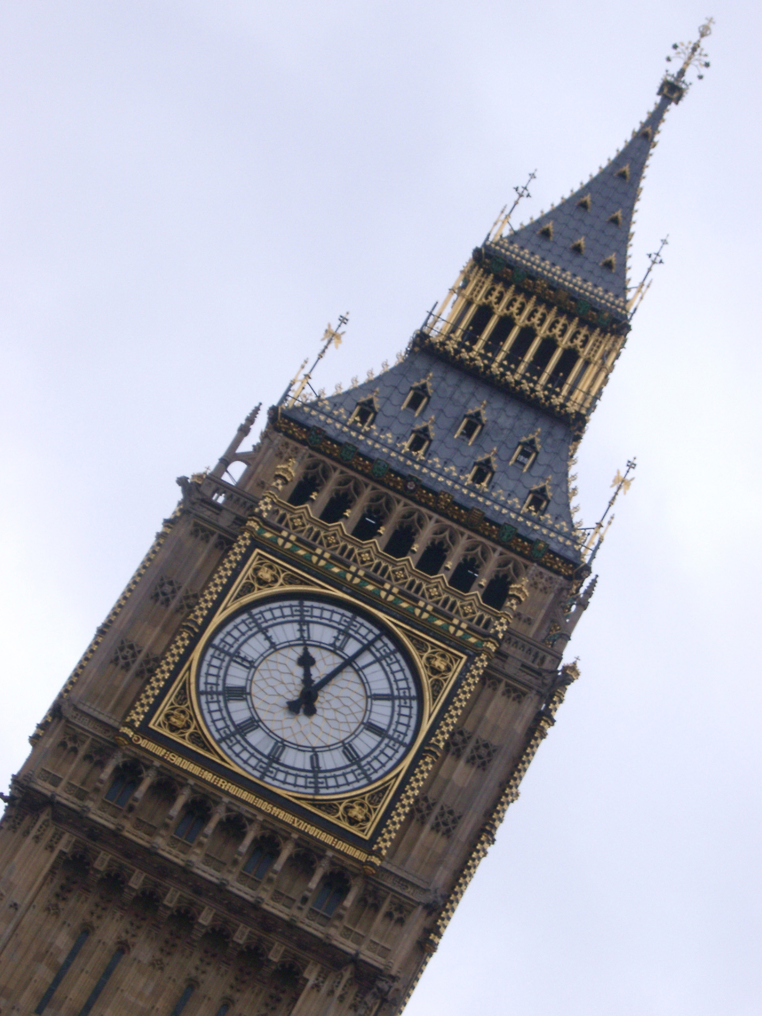 an image of Big Ben - low angle view of the famous Clock Tower in City of Westminster, England. Captured with Very Light Blue Sky Background.