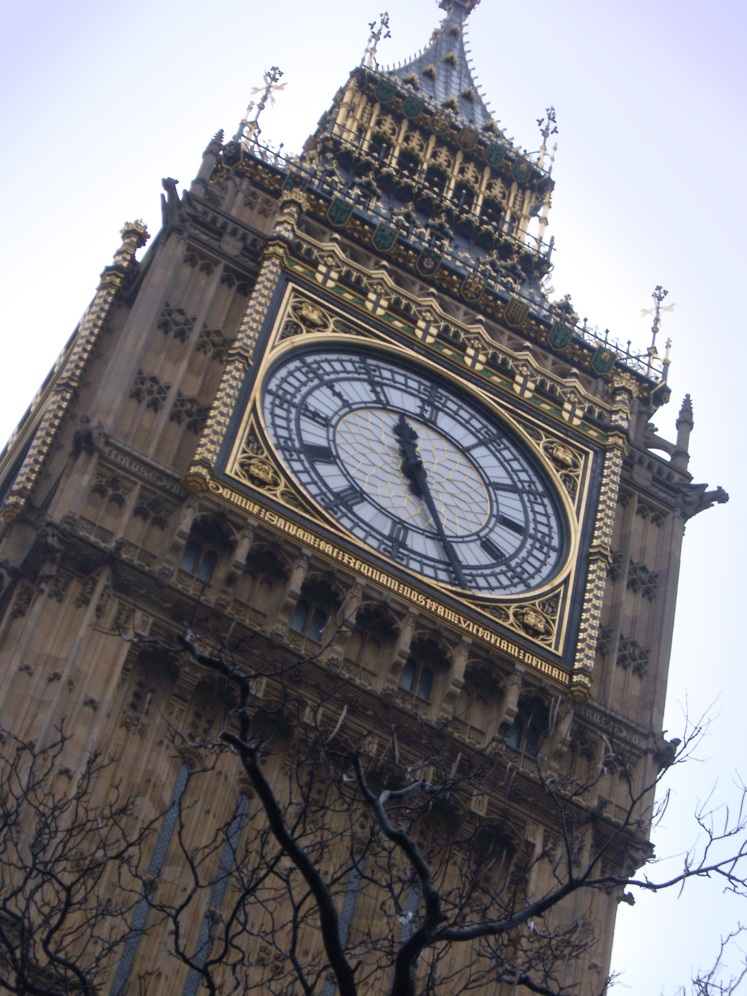 an image of detail of the dial of one of the clocks and the ornate Gothic stone facade of the Clock tower on the Palace of Westminter, London