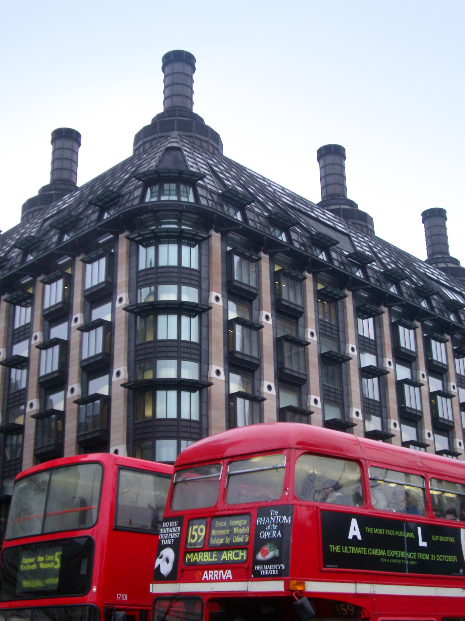an image of Red Buses on the Street in Front of Famous Portcullis House in Westminster, England.