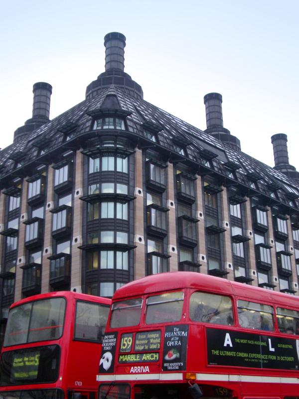 Red Buses on the Street in Front of Famous Portcullis House in Westminster, England.