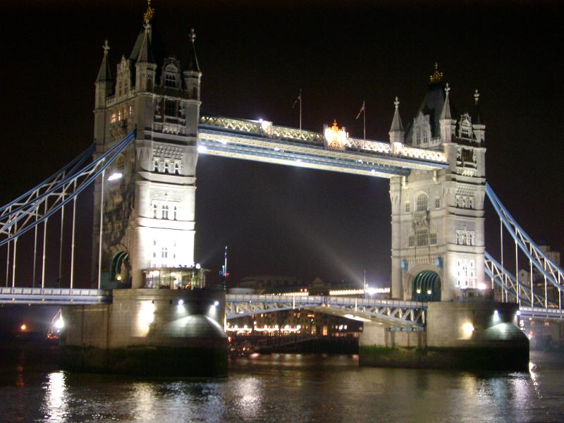 Tower Bridge, London, on the River Thames illuminated at night with the drawbridge down and reflections on the calm water