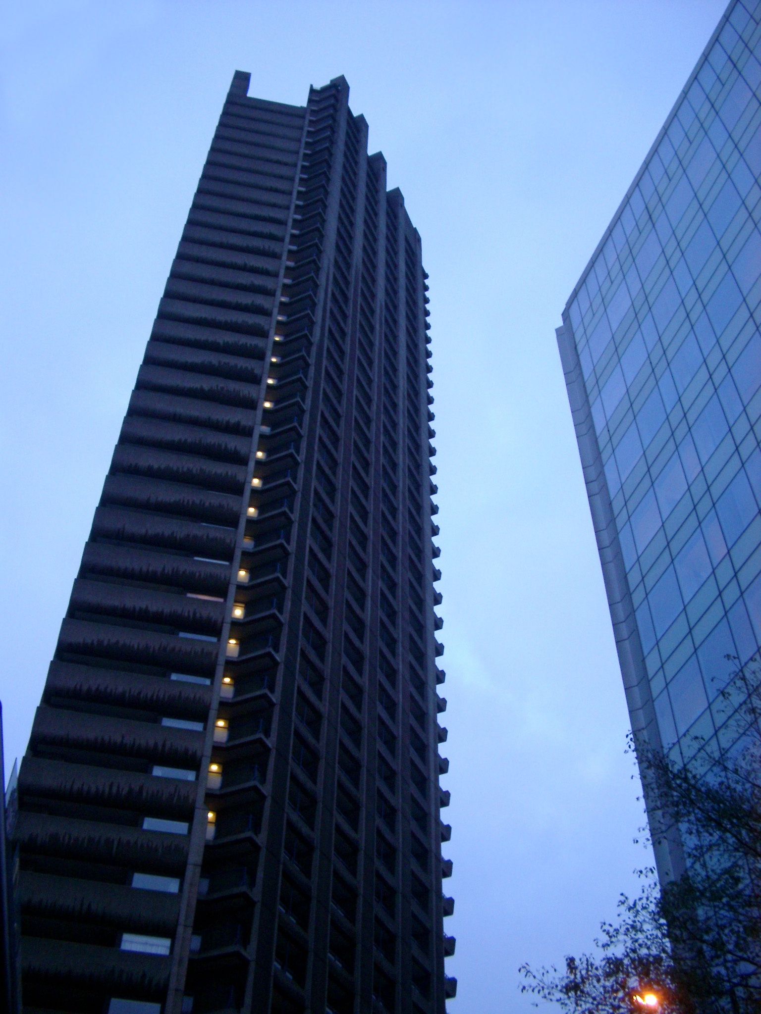 an image of Bruralist Architecture, the Towers of Barbican Estate, a Residential Estate in the City of London. Captured from Lower Angle Point with Light Blue Sky Background.