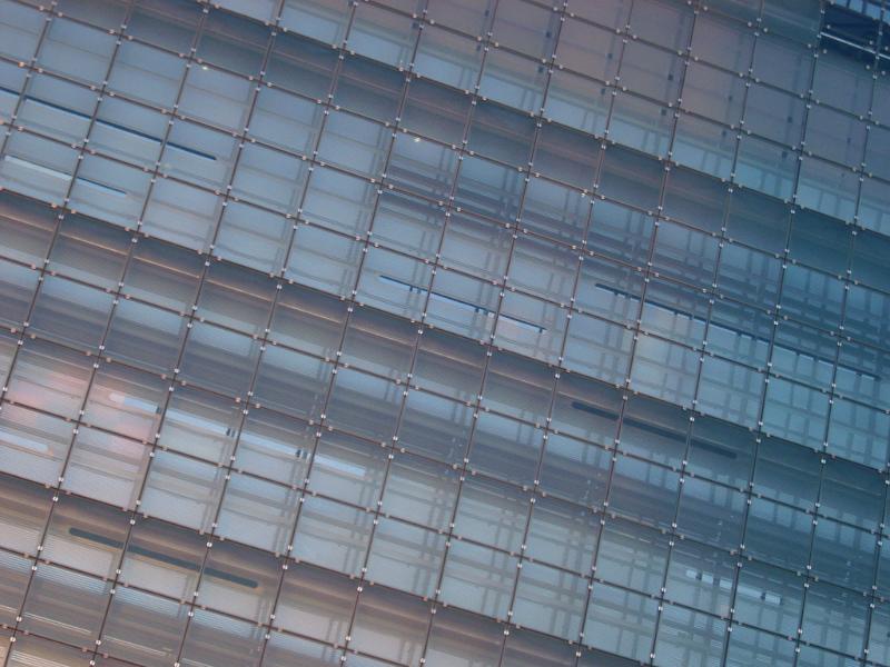 Oblique architectural close-up of the glass facade of a modern urban building