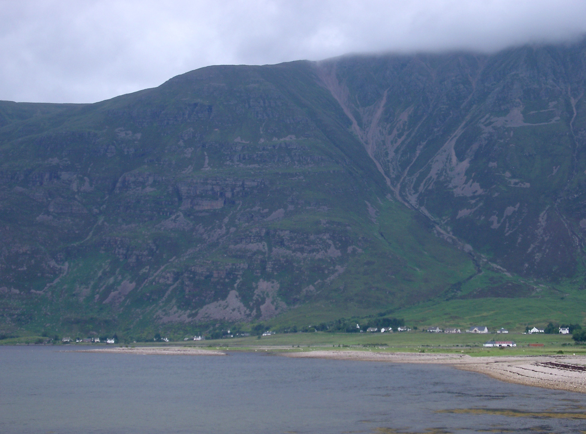 an image of Beach and small settlement on the shores of a loch in the Scottish highlands pictured on a cold misty day