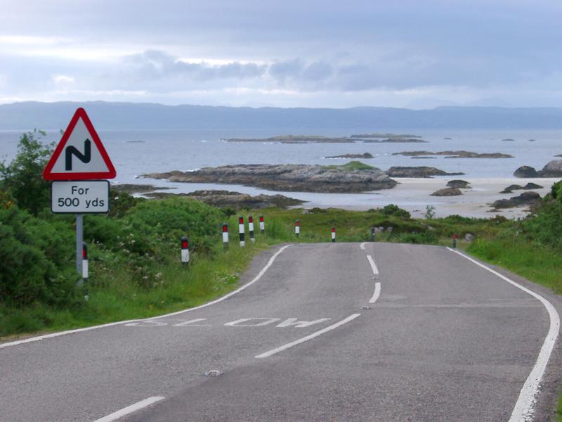 Scottish roads Scottish roads showing a curving bend with a hazard sign warning of bends for 500 yards along a section of the coastline