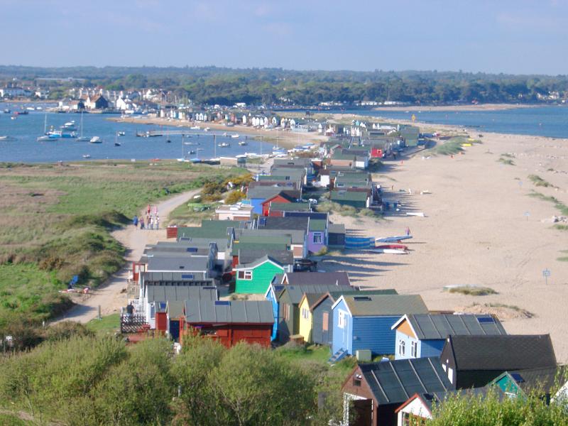 Row of colorful beach huts or cabins Row of colorful beach huts or cabins for vacations and getaways lining the Dorset seashore, high angle landscape view