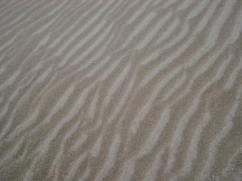 Textured Beach Sand with Abstract Design Close up Textured Beach Sand with Abstract Design for Wallpaper Backgrounds.