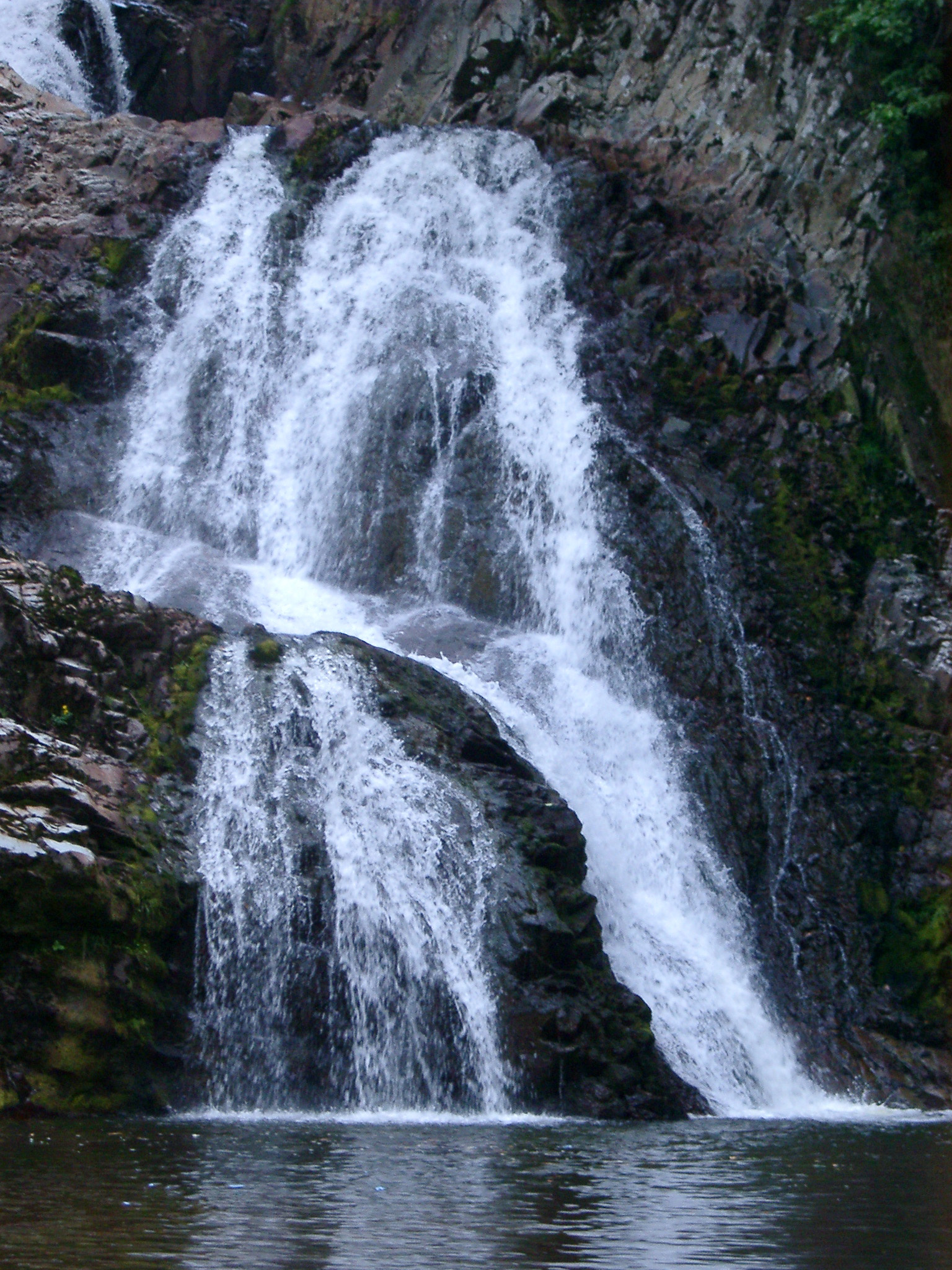 an image of Spectacular Rhaeadr Mawddach waterfall with cold water flowing over the steep rock into the river, in Wales, UK, Europe