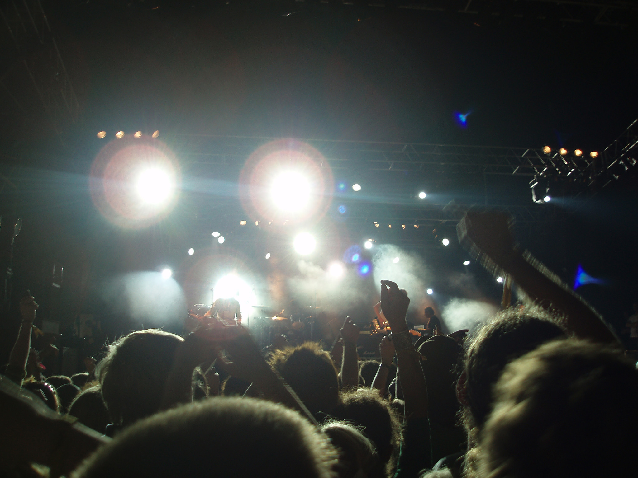 an image of People at the Crowd Enjoying the Night Concert While Artists Performing.