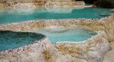 Aquamarine water and mineral deposits of the natural thermal pools in China used for therapeutic treatments due to the high mineral content of the water