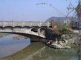 Famous Structure of Old Vintage Rural Stone Arch Bridge in China on Lighter Blue Sky Background.